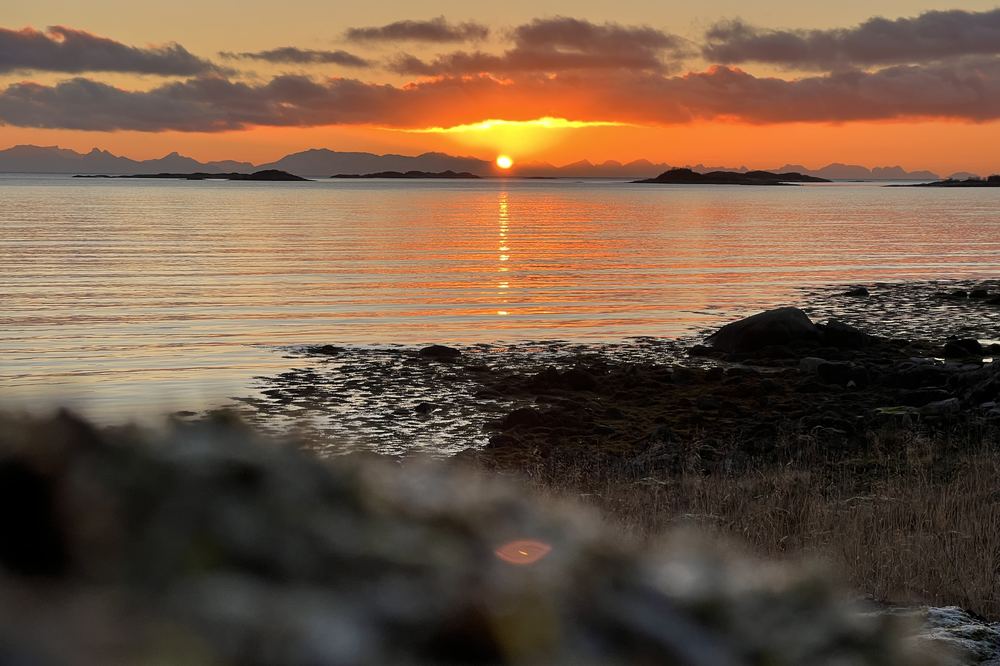 Solnedgang over havet sett fra fjæra